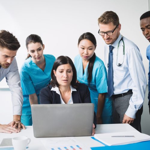Team of doctor discussing over laptop in meeting at conference room